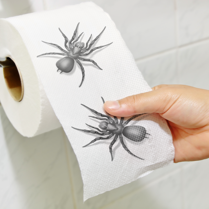Zdjęcie rolki papieru toaletowego z pająkiem umieszczonej w toalecie.