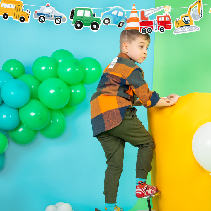 Zdjęcie aranżacyjne z chłopcem z girlandą z kolekcji Auta i czapeczką imprezową na głowie