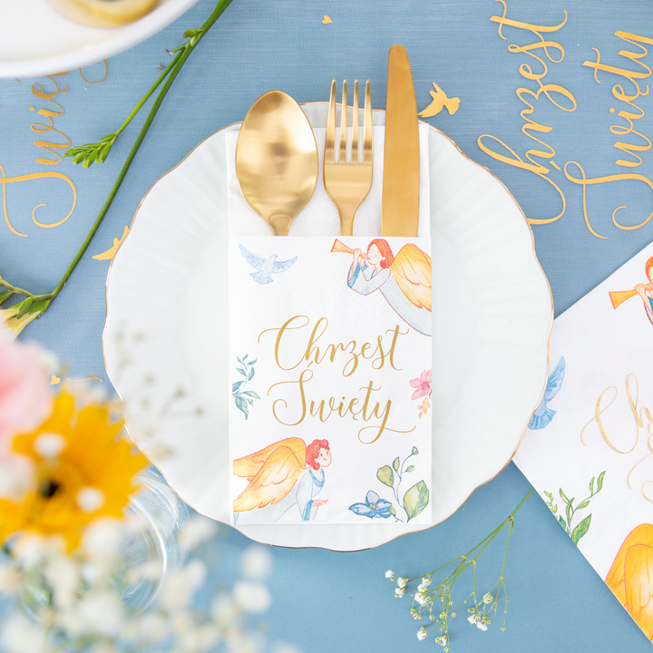 Kieszonka na sztućce z kolekcji Anioły , ze złotymi sztućcami na białym talerzu.