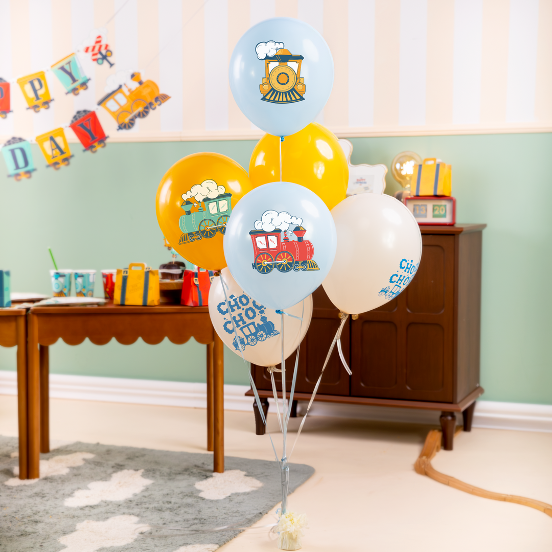 balony lateksowe z motywem ciuchci napisami choo choo, banner w kształcie pociągu, ciuchcią i wagonikami z węglem i napisem happy birthday,torebki na cukierki walizeczki, kubeczki z motywem ciuchci, szary dywan z białymi chmurami, stół i komoda w kolorze brązowym