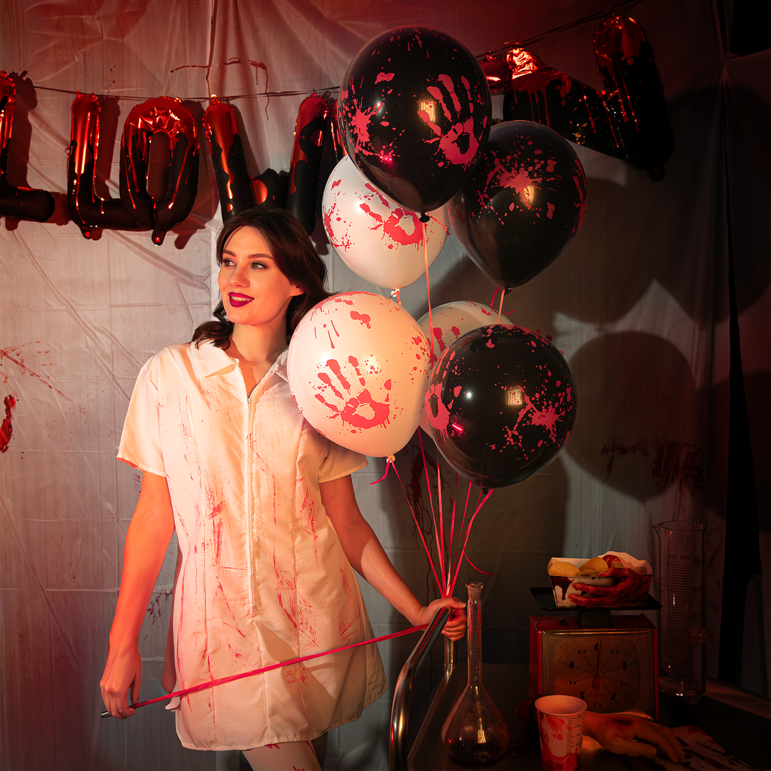 dziewczyna trzymająca balony lateksowe białe i czarne z nadrukiem zakrwawionej dłoni i plam krwi z kolekcji bloody na halloween, w tle napis z balonów foliowych. 
