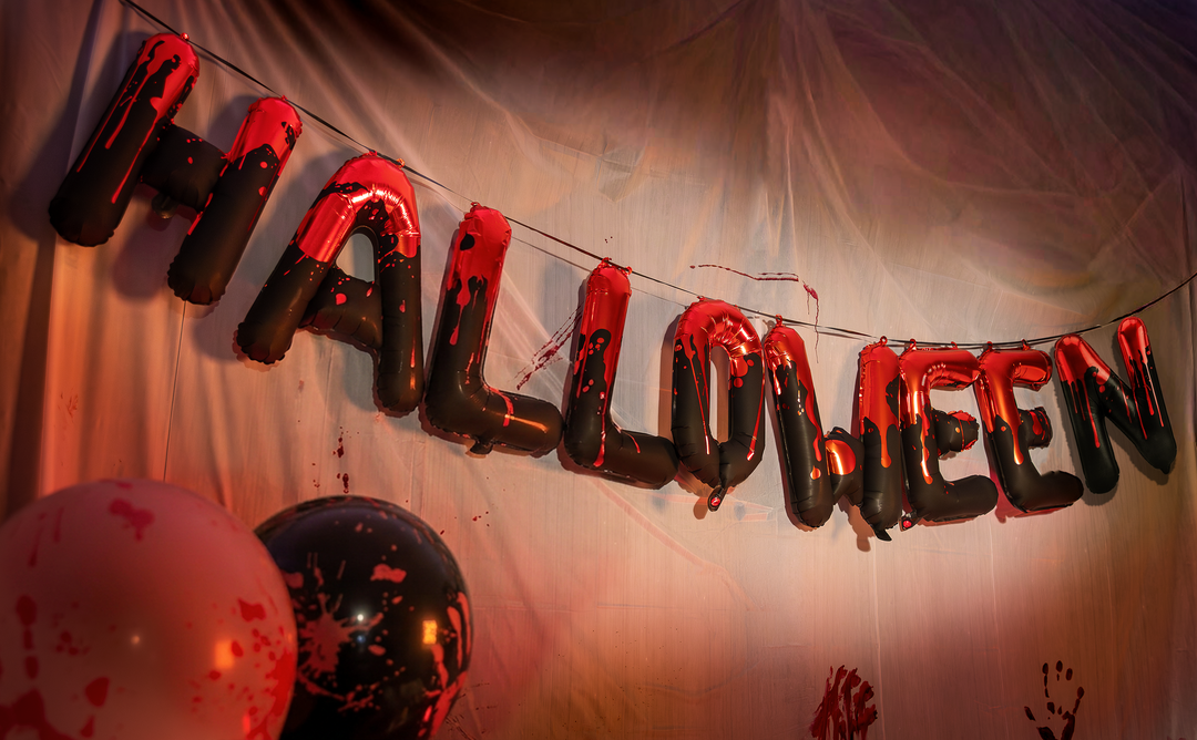 wiszący napis halloween z balonów foliowych w kolorze czarno czerwonym na tle ściany
