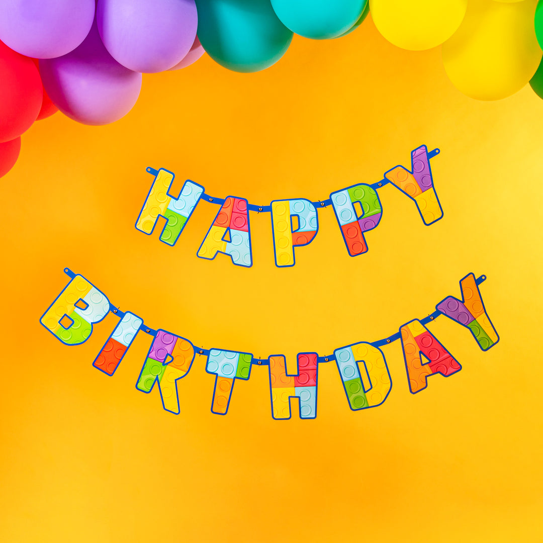 Kolorowy baner Happy Birthday Klocki na żółtym tle.