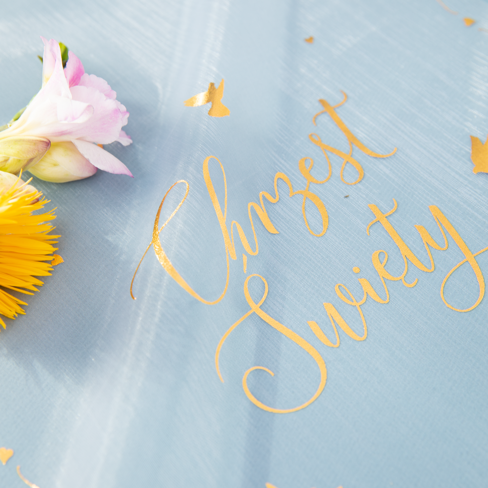 Fragment bieżnika z napisem Chrzest Święty na niebieskim tle