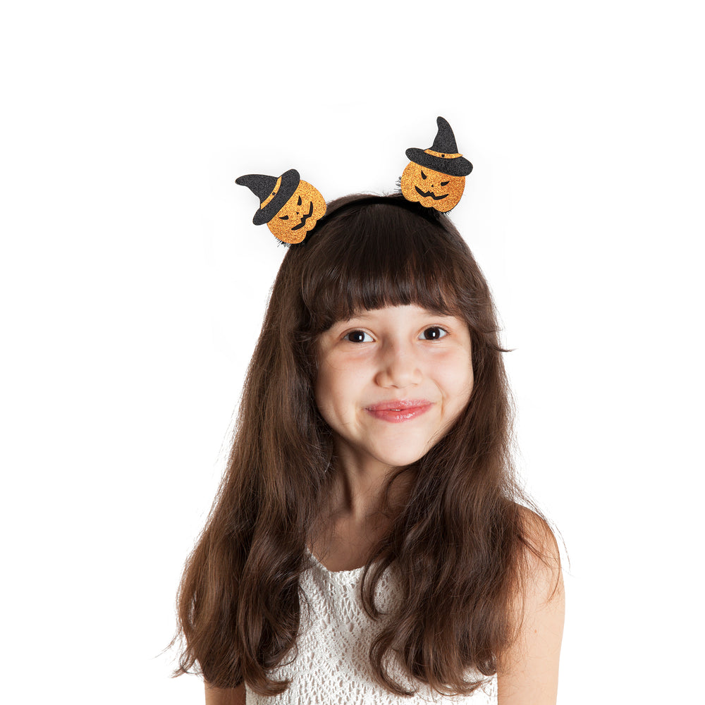 Dziewczynka zw opasce Halloween z dyniami na głowie