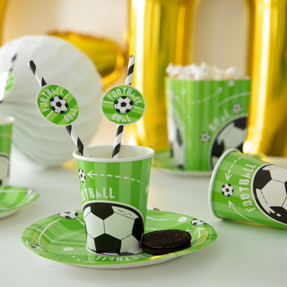 Na pierwszym planie znajduje się kubeczek ze słomkami oraz talerzyk z kolekcji Football.