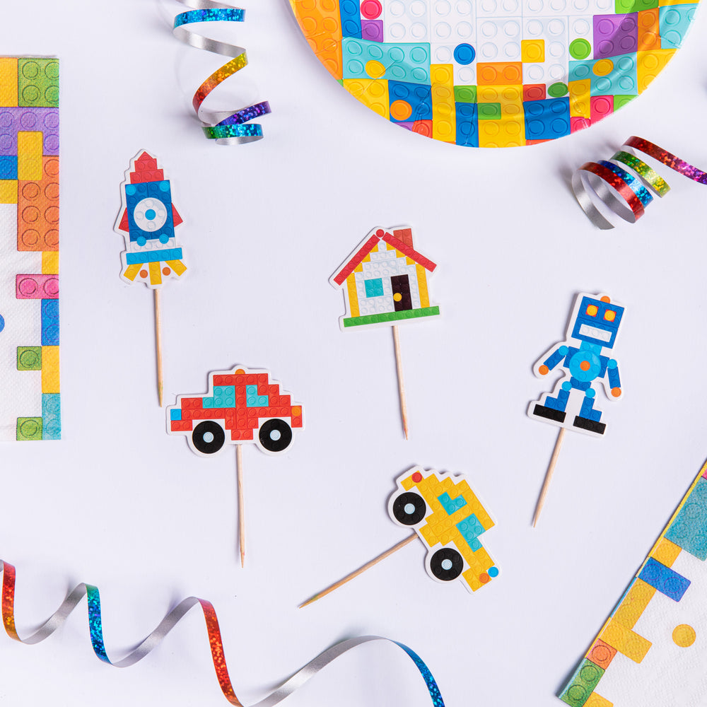 Toppery na tort z grafiką figurek z klocków lego leżące na białym stole.